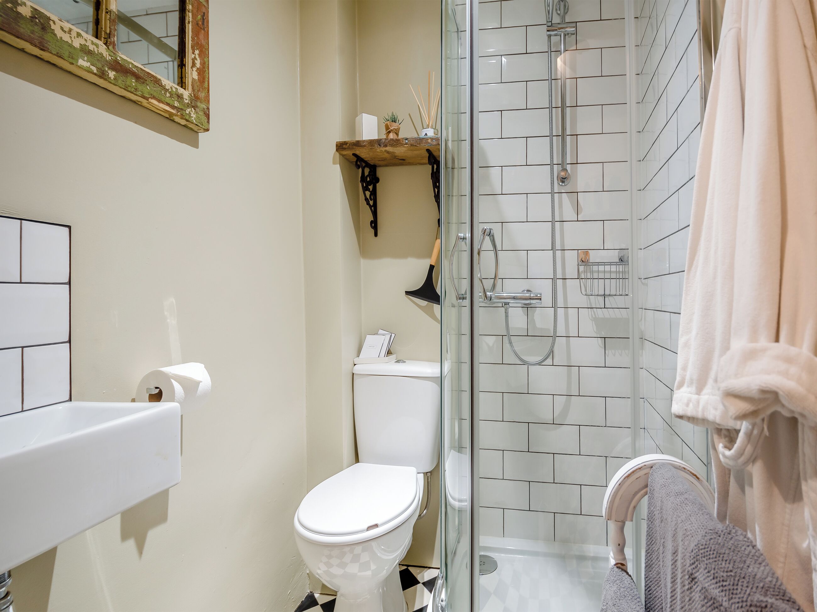 A bathroom with a toilet, a glass-enclosed shower, and a white sink.