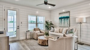 A living room with a sofa, armchairs, a coffee table, and a floor lamp.