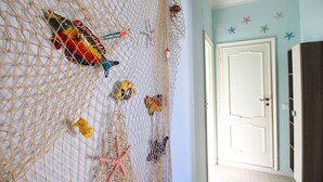 A room with a netted wall decoration featuring various sea-themed items like a fish, starfish, and a seahorse.