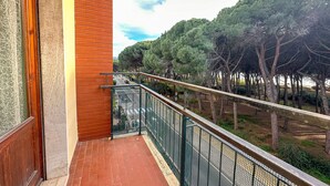 A balcony with a view of a road and trees.