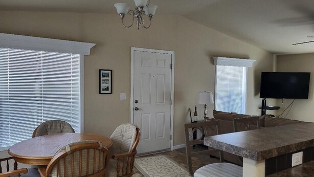 A dining area with a round table and chairs, a kitchen counter, and a television. - Lake Roosevelt View Retreat Grand Coulee (Grand Coulee)