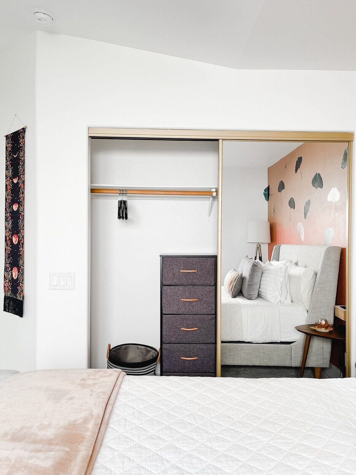 A bedroom with a bed, a wardrobe, a bedside table, and a nightstand.