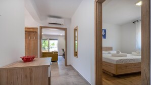 Une chambre d’hôtel moderne avec un lit en bois, un petit bureau et une vue sur l’extérieur.
