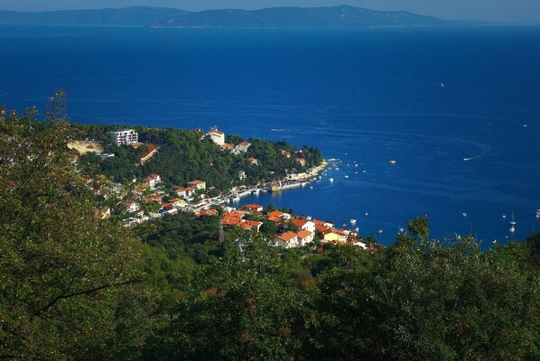 A coastal town with buildings along the shoreline, a marina with boats, and a mountainous backdrop. - New villa with a pool and a 4,000 m² private garden (Šumber)