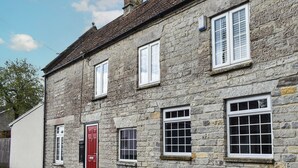 A stone building with multiple windows and a red door. - 2 bedroom accommodation in Street (Street)