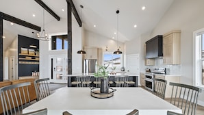 A spacious kitchen with a large island, modern appliances, and a view of the outdoors. - Highland Chateau at Longridge  (Sleeps 34) (Garden City)