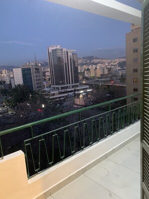 A cityscape view from a balcony with a green railing. - Beautiful app (Forn El Chebbak)