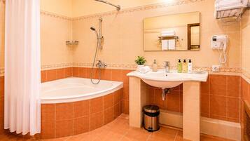 A bathroom with a bathtub, a sink, a mirror, a towel rack, and a trash can.