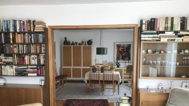 A room with a dining area, a bookshelf, and a large rug. - Doppelhaushälfte mit Garten ca. 130qm (Radolfzell am Bodensee)