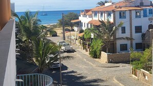 Vista costera con edificios, cielo despejado y el mar al fondo.