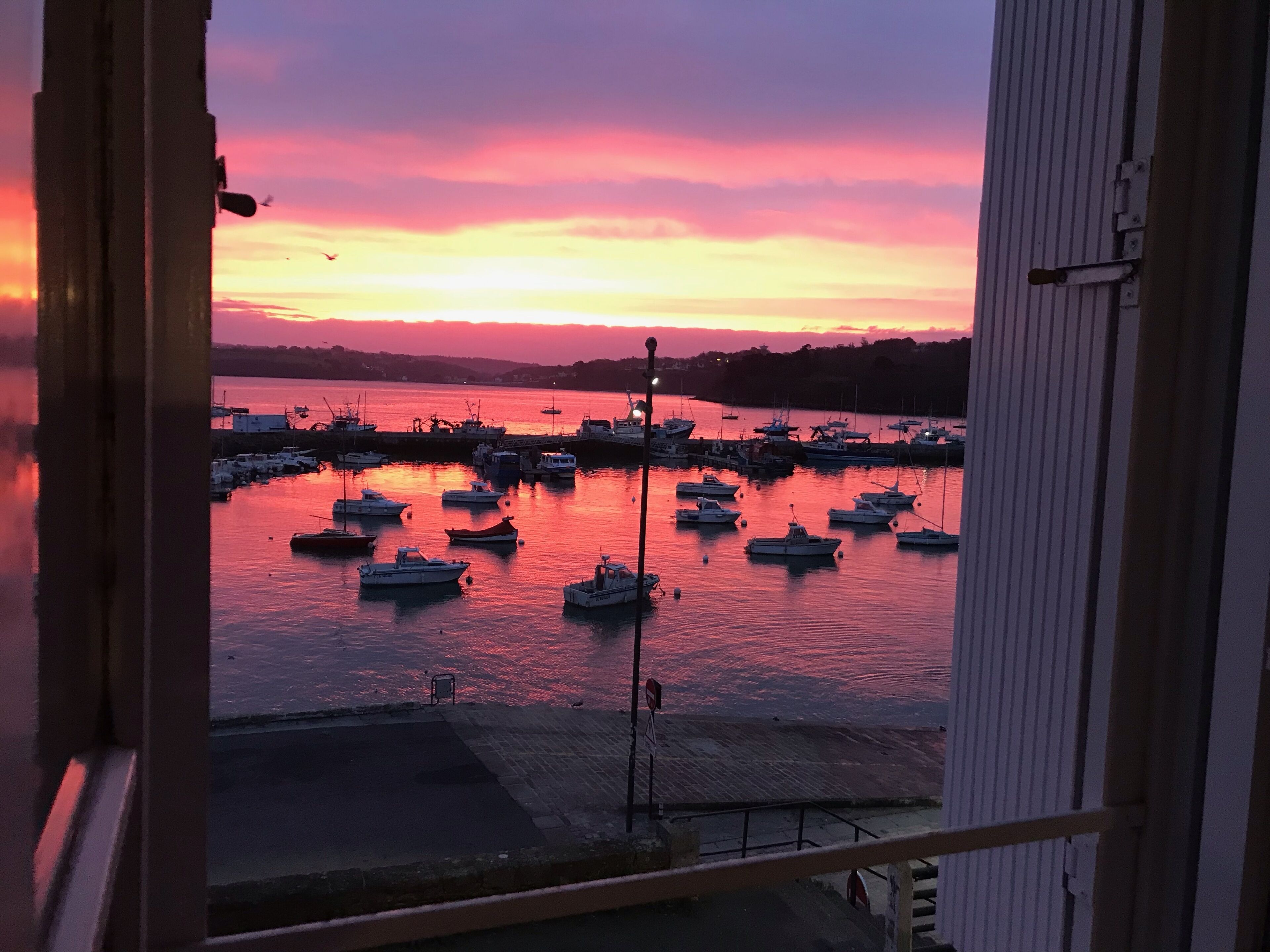A harbor at sunset with boats docked.