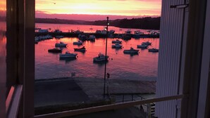 Un puerto al atardecer con barcos amarrados.