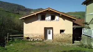 Una casa a due piani con fondamenta in pietra e tetto in tegole.
