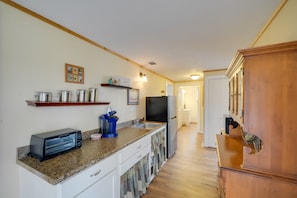 A kitchen with a toaster, sink, and wooden cabinets.