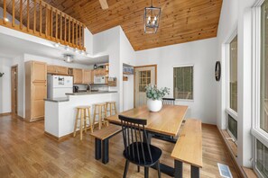 A spacious kitchen with wooden cabinets, a central island, and a dining area with a wooden table and chairs.