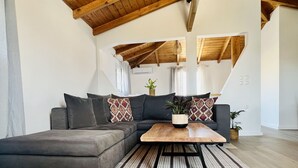 Una sala de estar moderna con un sofá modular, una mesa de centro de madera y una alfombra a rayas.