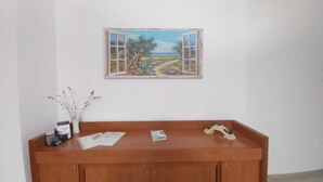 Un escritorio de madera con papeles, un jarrón con ramas y una maqueta de un puente.