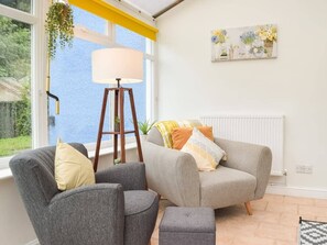 A living room with two grey armchairs, a floor lamp, and a view of the sea through a large window. - Synod Cottage | Private Hot Tub, Dog Friendly, Near New Quay (Ceredigion)