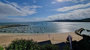 A coastal view with boats docked at a pier, a sandy beach, and a clear sky. - Pet-Friendly Country Escape HotTub & Log Burner (Ceredigion)
