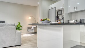 A modern kitchen with white cabinets, a granite countertop, and a built-in oven. - Tristão Vaz I, a Home in Madeira (Machico)