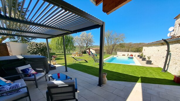 Un patio couvert avec des meubles d’extérieur, une piscine et une pelouse bien entretenue.