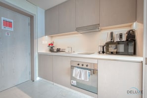 A modern kitchen with a built-in oven, microwave, and coffee maker.