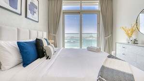 A hotel room with a large bed, a dresser, a mirror, and a view of the sea. - Idyllic 1BR at Sunrise Bay Tower 1 Emaar Beachfront Dubai Marina by Deluxe Holiday Homes (Dubai)