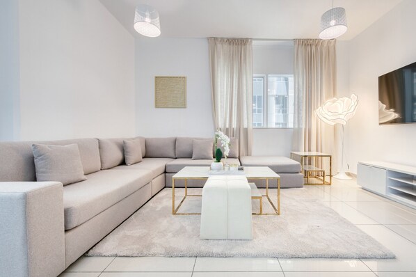 Ein modernes Wohnzimmer mit einem Ecksofa, einem weißen Couchtisch und einem kleinen Beistelltisch.