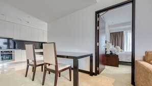Una camera d'albergo moderna con zona pranzo, un letto e vista sulla città.