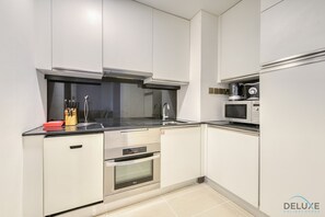 A modern kitchen with stainless steel appliances, a microwave, and a gas stove.