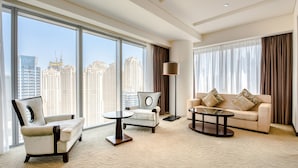 A spacious living room with large windows, a sofa, a chair, and a coffee table. - Pristine 3BR at The Address Residences Dubai Marina by Deluxe Holiday Homes (Dubai)