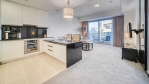 A modern kitchen with a central island, built-in appliances, and a dining area with a view of the city.