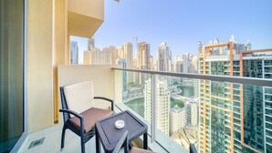 A balcony with a view of a cityscape, featuring high-rise buildings and a river.