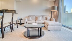 A modern living room with a round coffee table, a sofa, and a dining area with chairs.