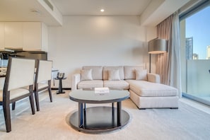 A modern living room with a round coffee table, a sofa, and a dining area with chairs.