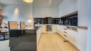A modern kitchen with white cabinets, stainless steel appliances, and a black countertop.