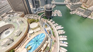 A high-rise building with a circular swimming pool and a marina with boats.