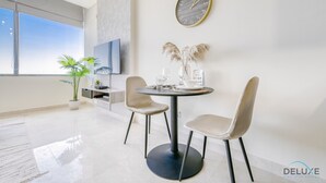 Un comedor moderno con una mesa redonda, dos sillas, un reloj y una planta en maceta.