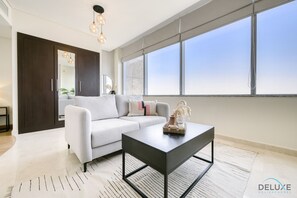 Un salon moderne avec un canapé, une table basse et une grande fenêtre offrant une vue dégagée.