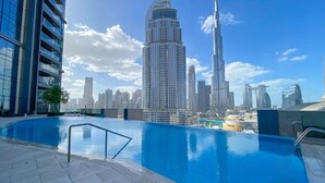 Une piscine sur le toit, avec la vue sur les gratte-ciel de la ville en arrière-plan, dont le Burj Khalifa.