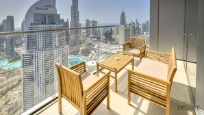 Un balcon offrant une vue sur le paysage urbain, notamment sur le bâtiment Emaar et le Burj Khalifa.