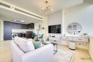 Een moderne woonkamer met een bank, salontafel en een aan de muur bevestigde televisie.