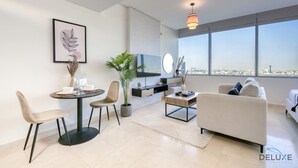 Un soggiorno moderno con zona pranzo, TV a schermo piatto e un'ampia finestra vista città.