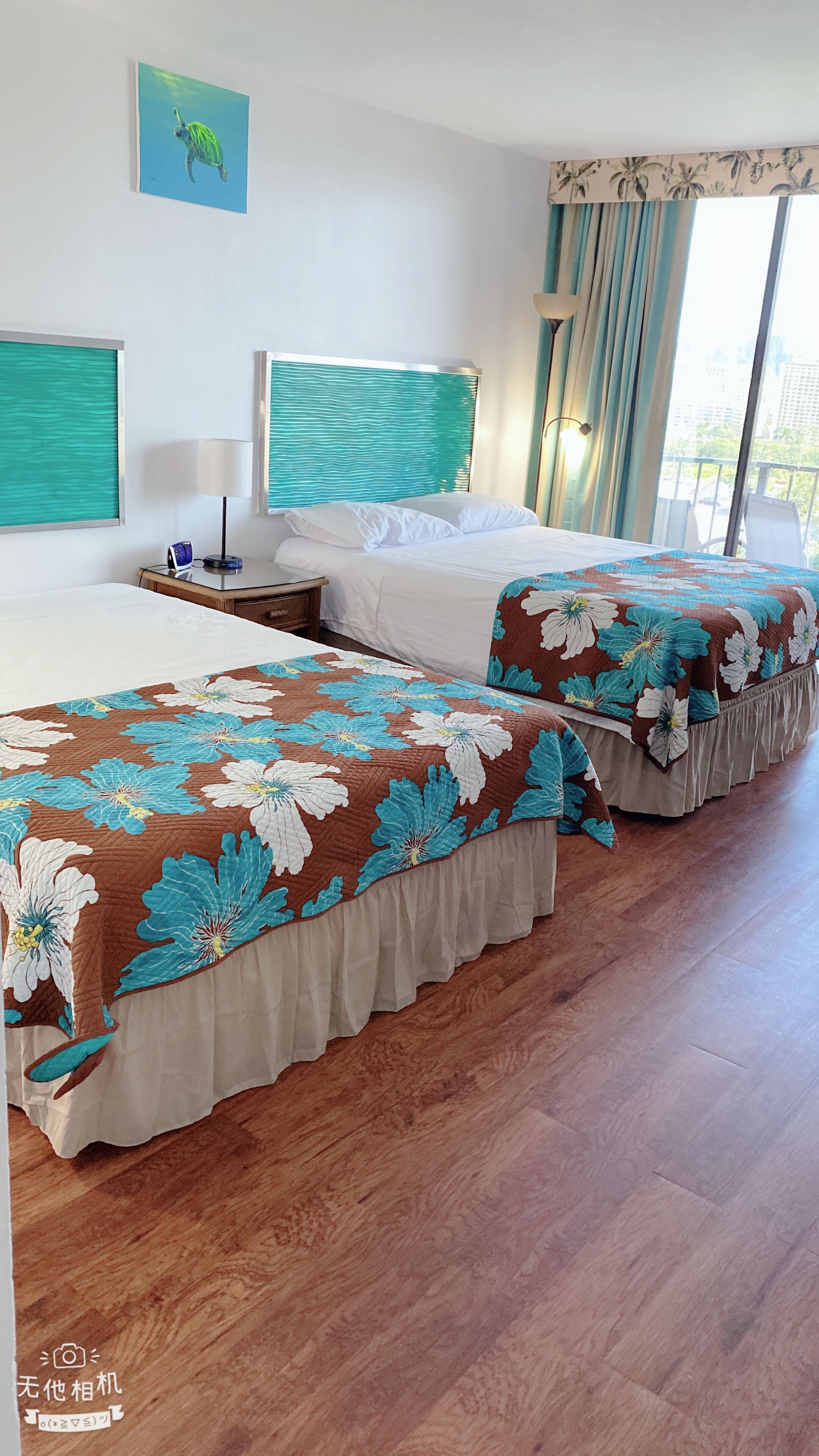 A hotel room with two beds, a window with curtains, a painting on the wall, and a wooden floor.