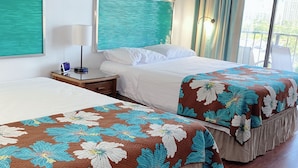 A hotel room with two beds, a window with curtains, a painting on the wall, and a wooden floor.