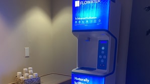 A water dispenser with a digital display, a control panel, and a label stating "Naturally brilliant water."