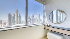 Un baño moderno con un ventanal grande, un espejo redondo y un tocador minimalista.