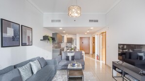 A modern living room with a grey sofa, a coffee table, and a TV stand. - Scenic 1BR at Ocean Heights Dubai Marina by Deluxe Holiday Homes (Dubai)