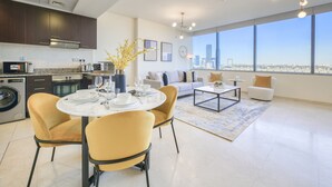 Espaço moderno com área de refeições, cozinha e amplas janelas com vista para a cidade.