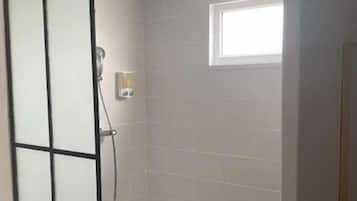 Een douche, handdoeken, zeep, shampoo